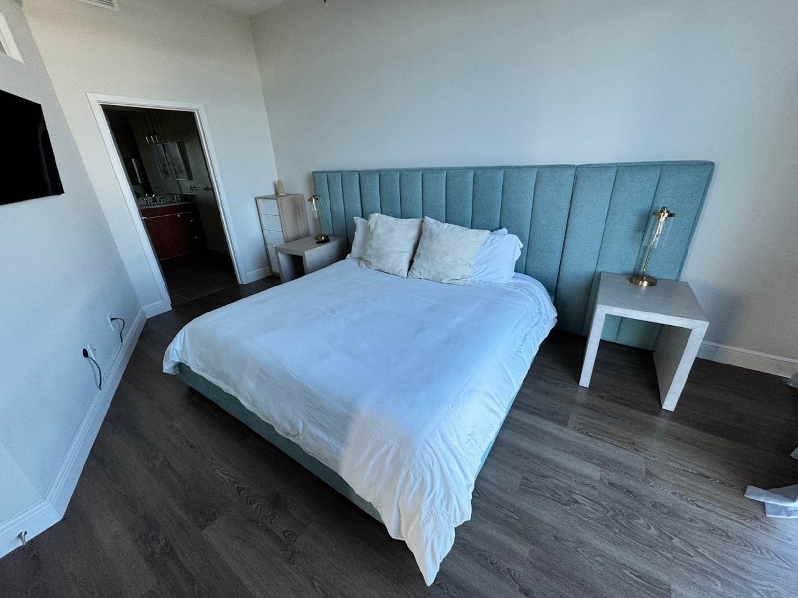 A bed with a blue headboard

Description automatically generated