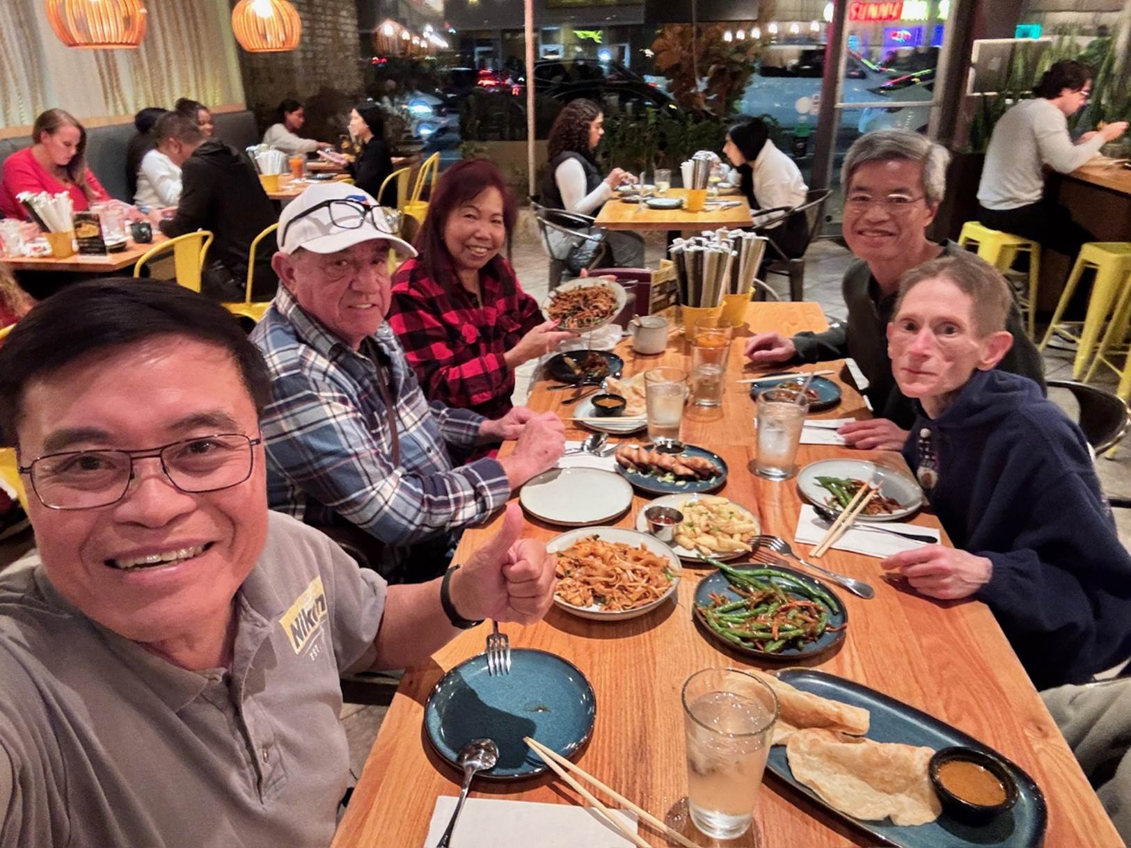 A group of people sitting at a table eating food

Description automatically generated