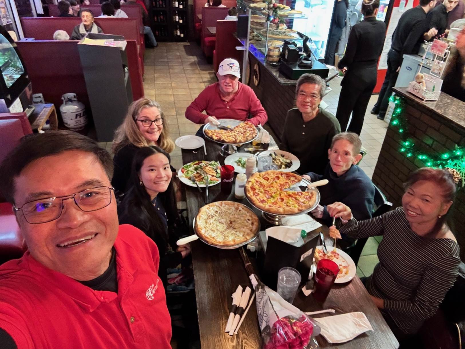 A group of people sitting at a table with food

Description automatically generated