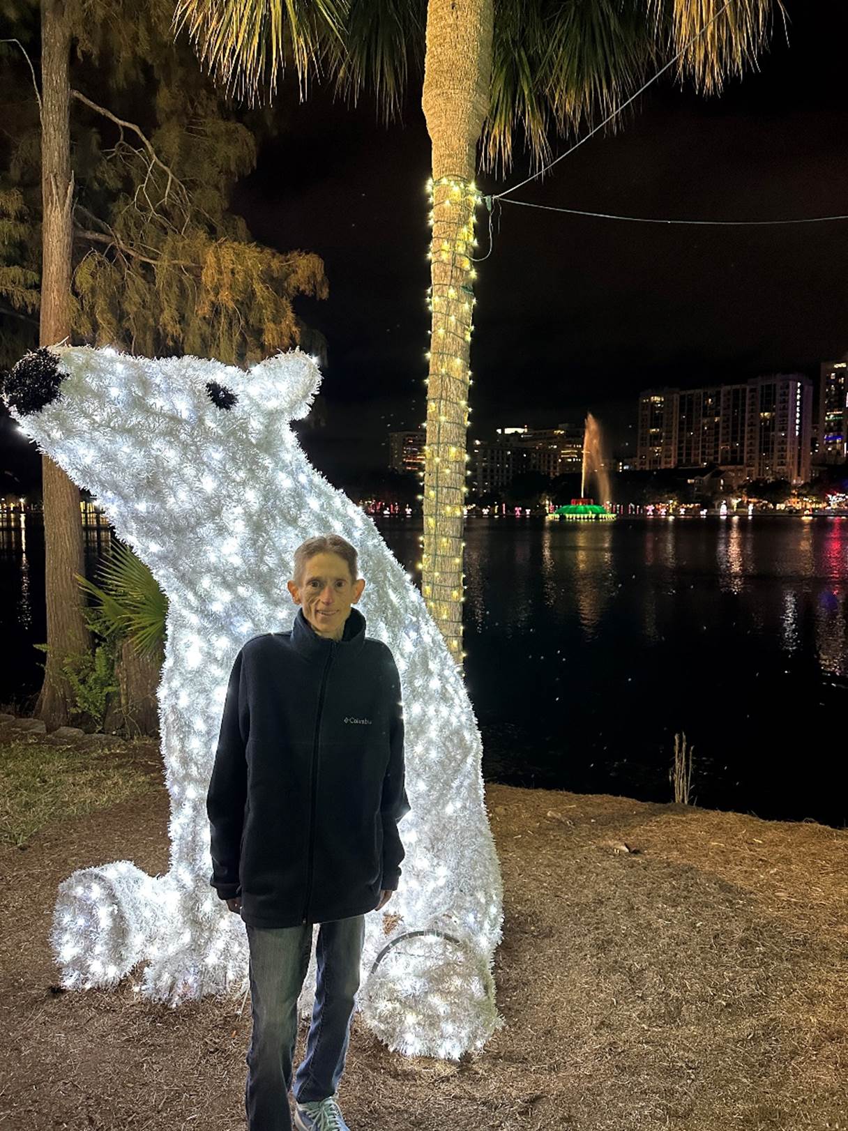 A person standing in front of a lighted polar bear statue

Description automatically generated