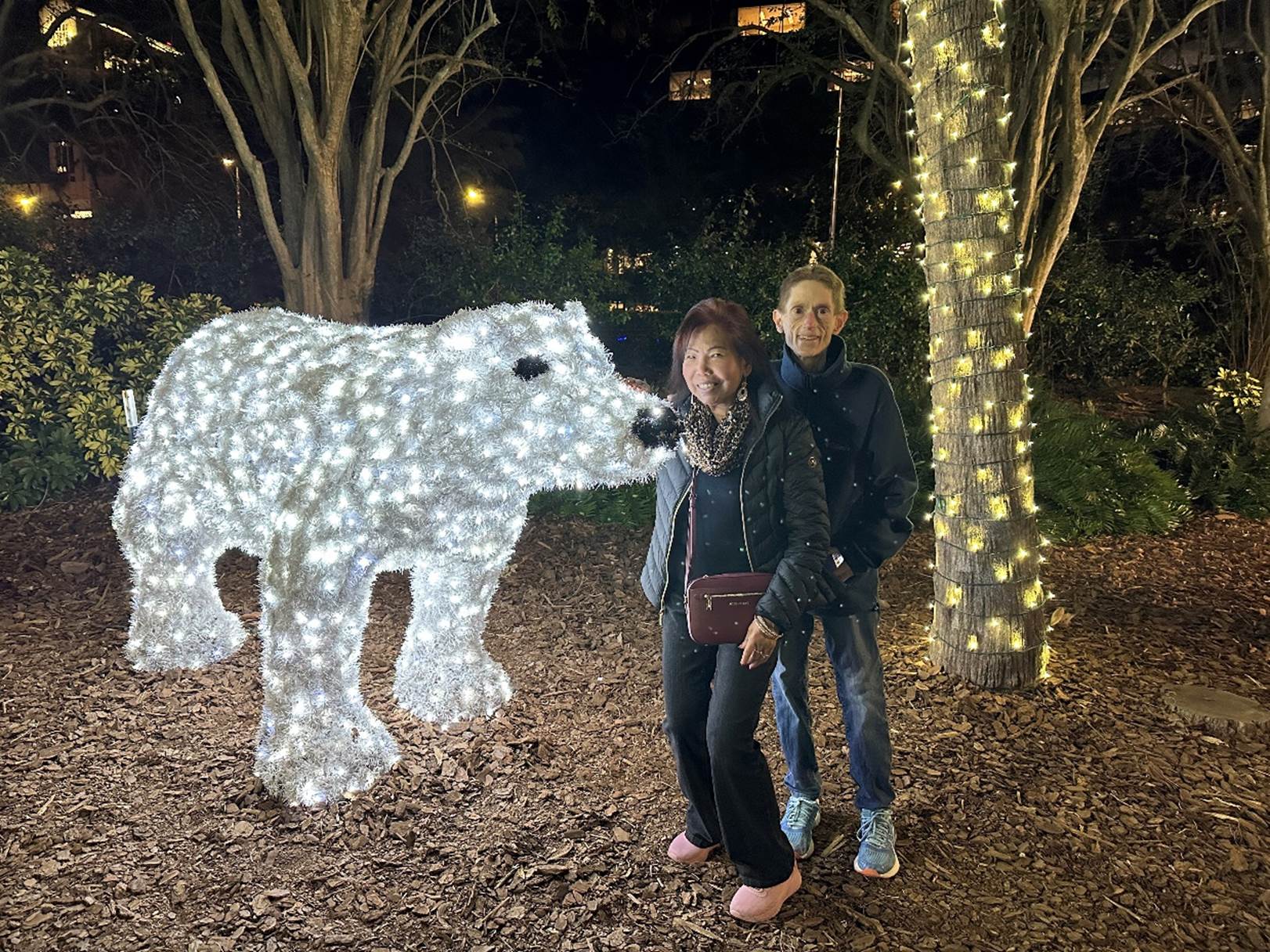 Two people posing with a polar bear statue

Description automatically generated