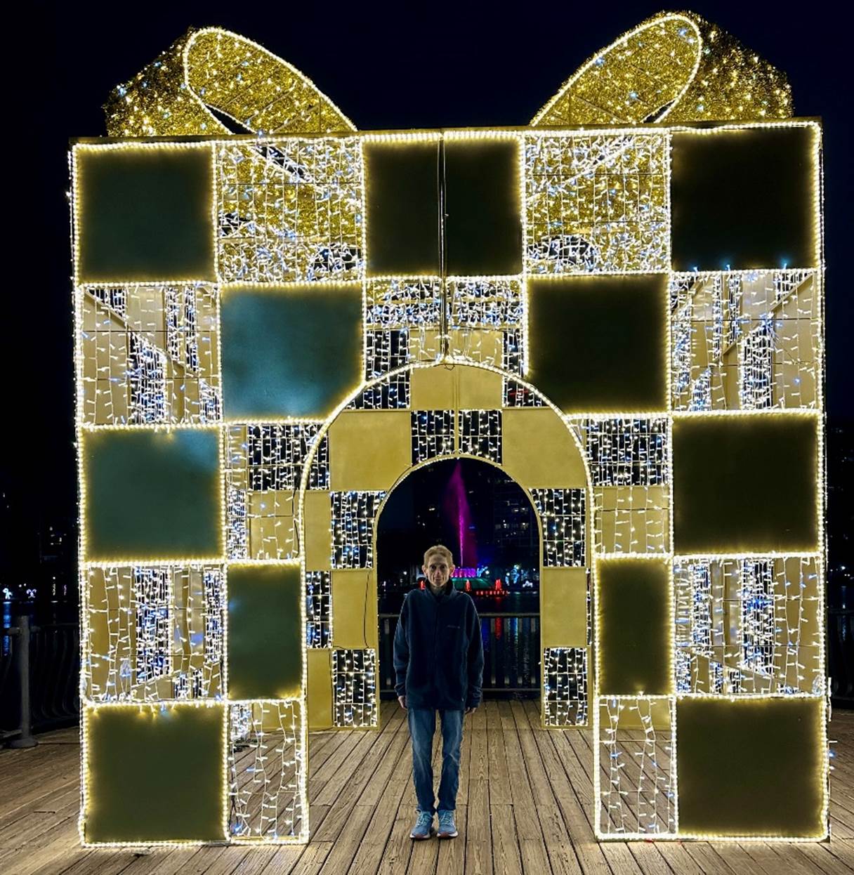 A person standing in front of a large gift box

Description automatically generated