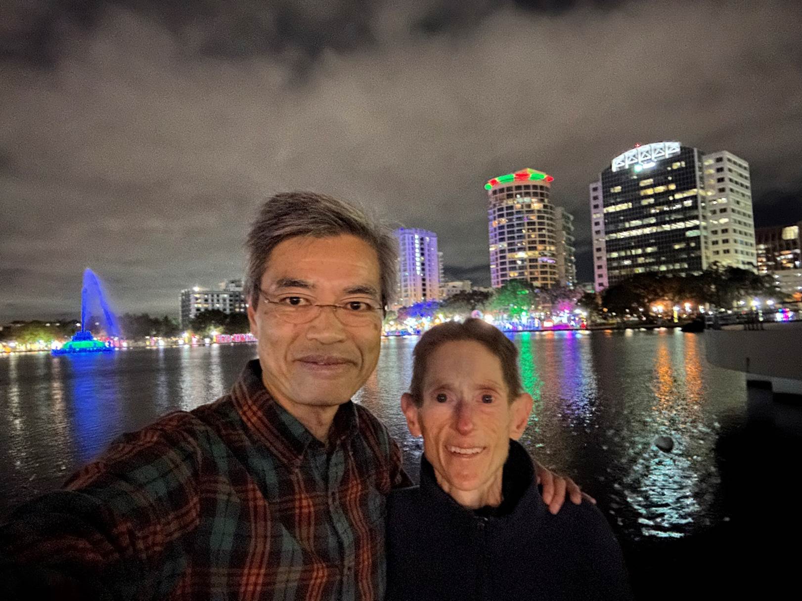 A person and person taking a selfie in front of a body of water

Description automatically generated