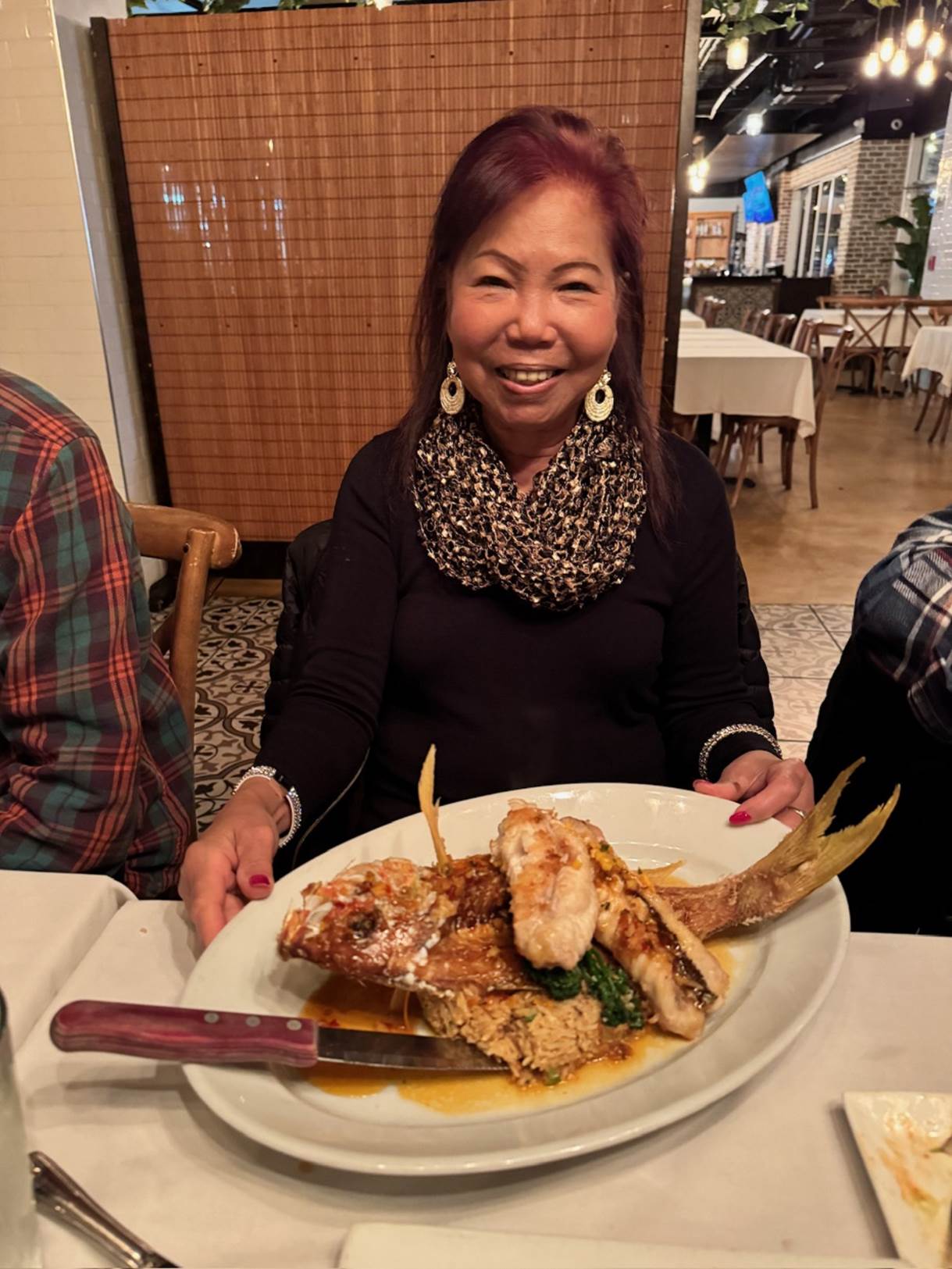 A person sitting at a table with a plate of food

Description automatically generated