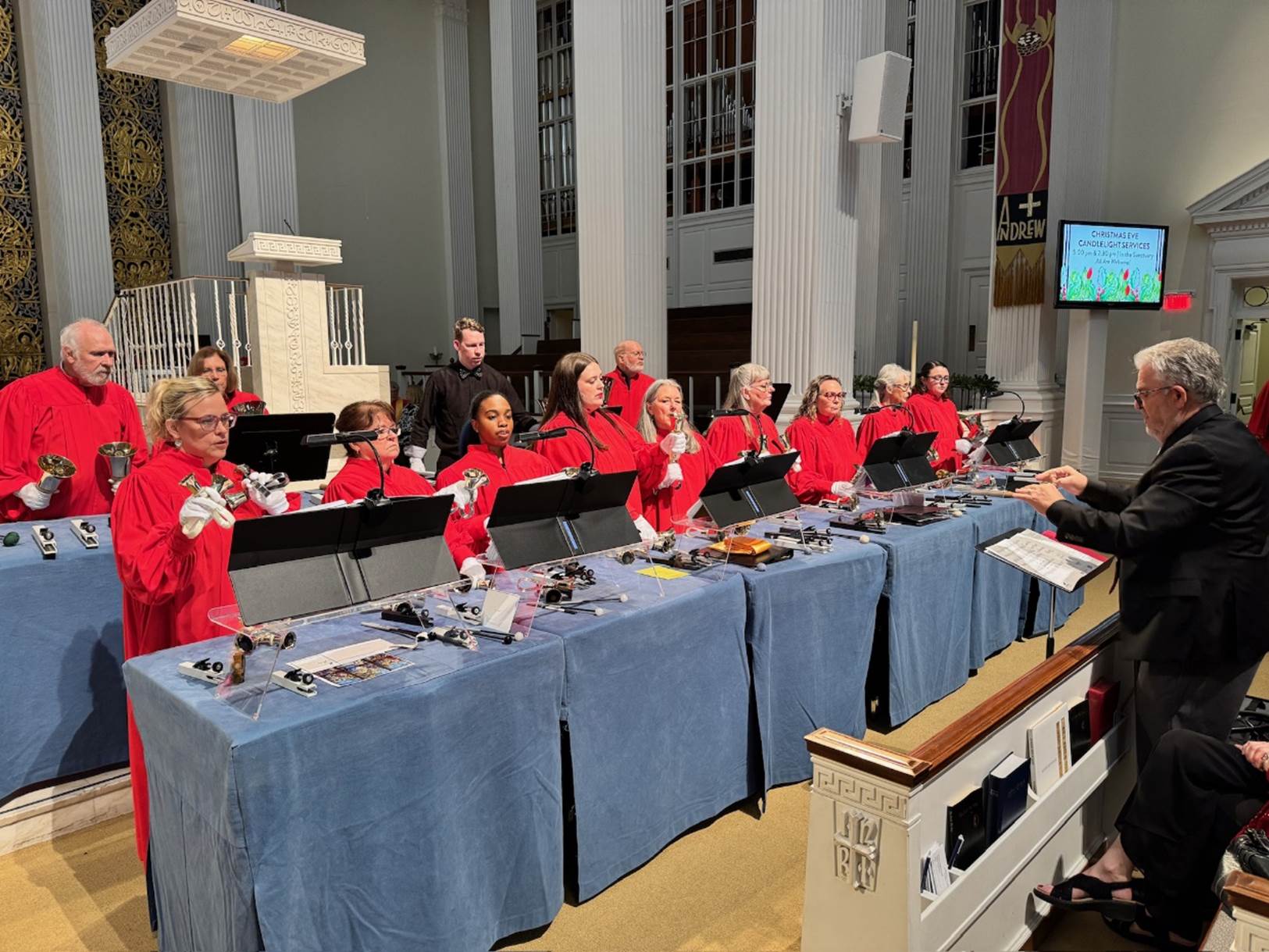 A group of people in red uniforms singing

Description automatically generated