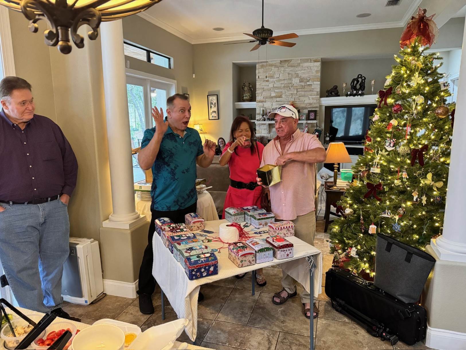 A group of people around a table with a christmas tree

Description automatically generated