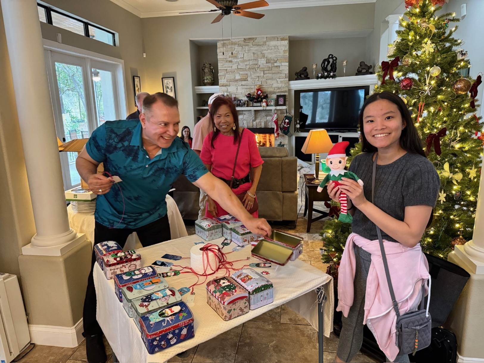 A group of people in a room with a table with presents

Description automatically generated