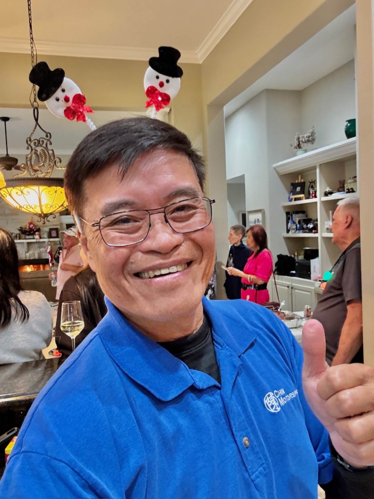 A person in a blue shirt giving a thumbs up

Description automatically generated