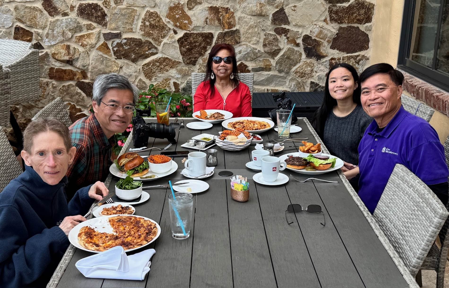 A group of people sitting at a table with food

Description automatically generated