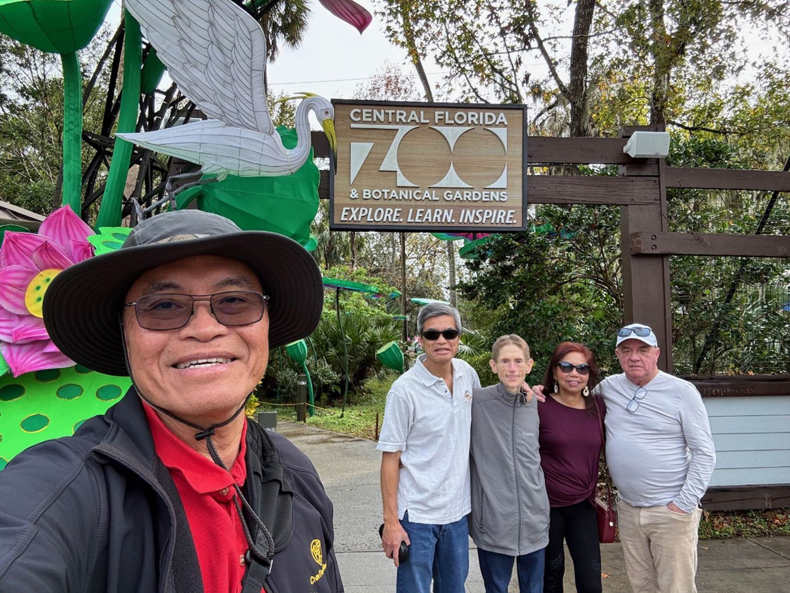 A group of people standing in front of a sign

Description automatically generated