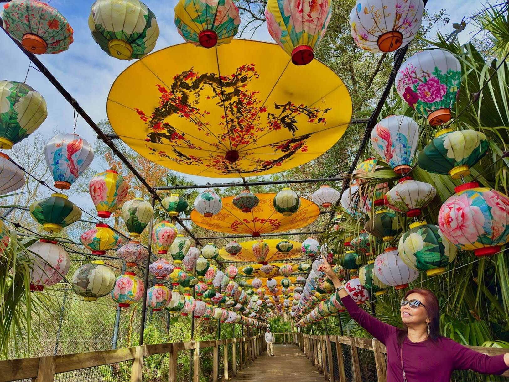A person standing under a bridge with lanterns

Description automatically generated