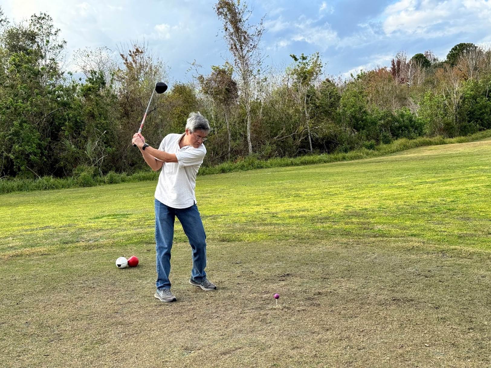 A person swinging a golf club

Description automatically generated