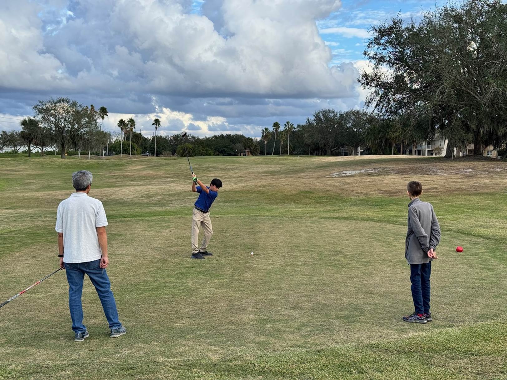 A group of people playing golf

Description automatically generated