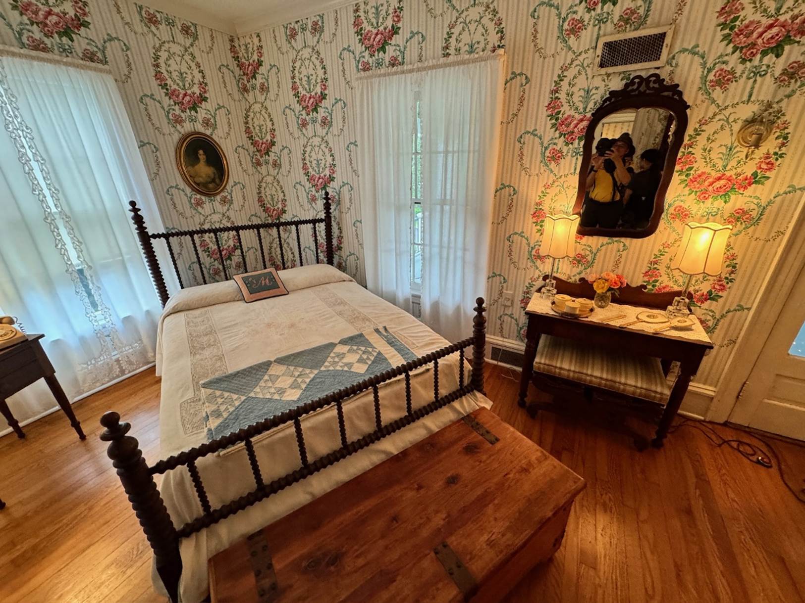 A bedroom with a bed and a mirror

Description automatically generated