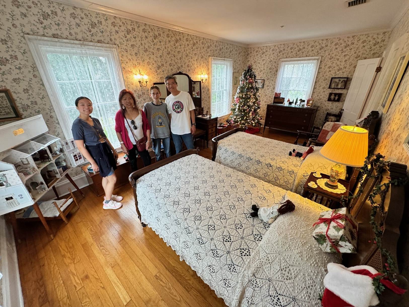 A group of people standing in a room with beds

Description automatically generated