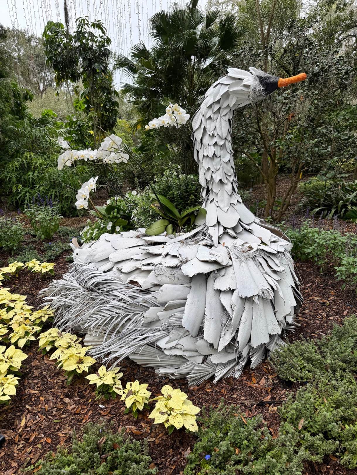 A sculpture of a swan in a garden

Description automatically generated
